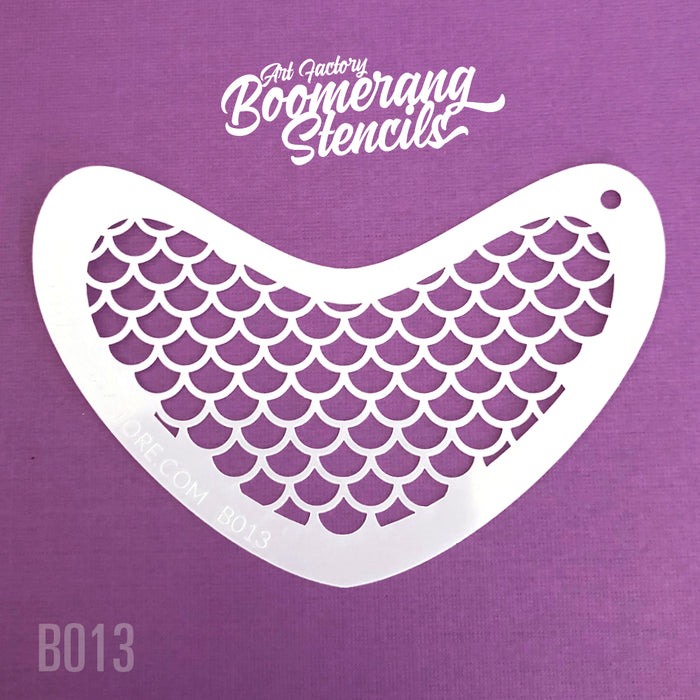 A white boomerang-shaped stencil with mermaid scale patterns on a purple background